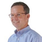 Headshot of man in blue shirt and glasses